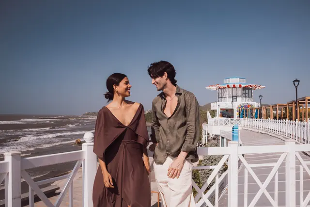 Pareja conversando en una terraza frente al mar