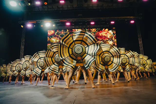 Presentación de danza con sombreros en un escenario