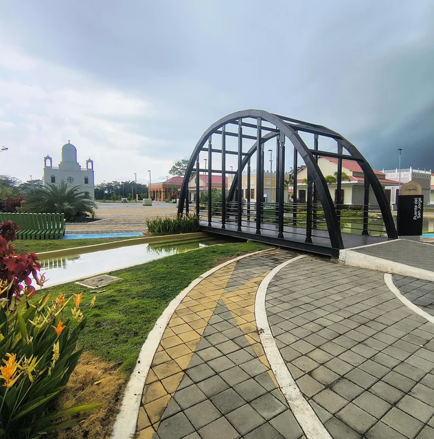Puente peatonal sobre un río y jardín ribereño