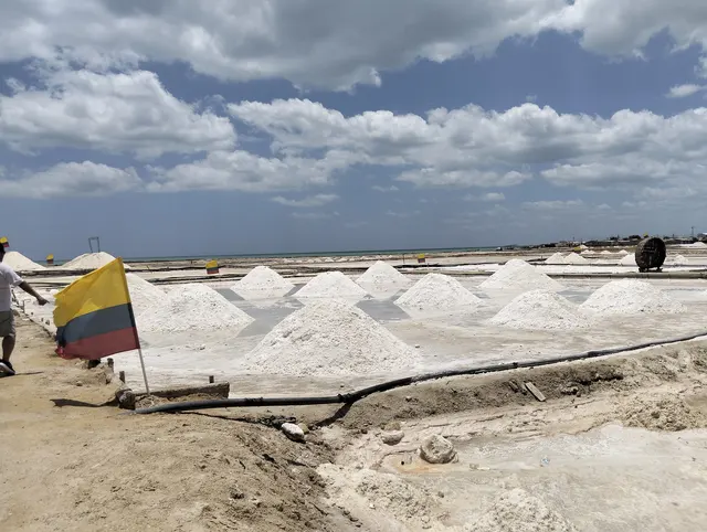 Paisaje de salinas bajo un cielo con nubes