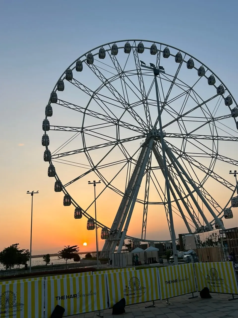 Rueda panorámica y atardecer junto al río